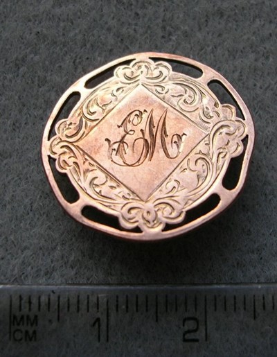 Gold round medal with central inscription EM