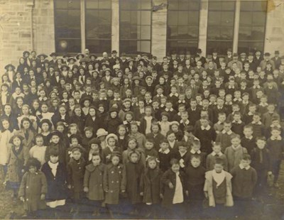 Photograph  of the pupils and staff of Dornoch Academy at opening ceremony by Lord Kennedy, 1913.