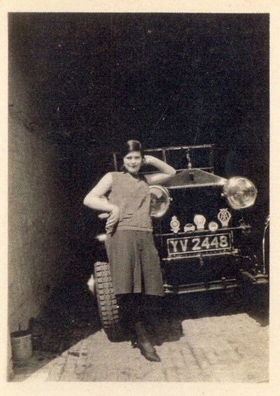 Margaret Munro posing by a garaged Rolls Royce car