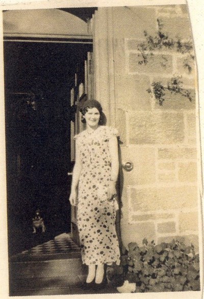 Margaret Munro at door to a house