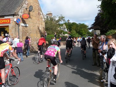 The tail end of the 'peloton' passing the Dornoch Post Office