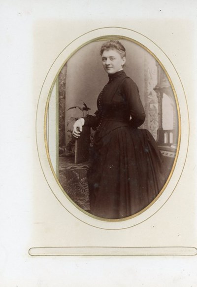 Studio portrait of a lady standing at a table