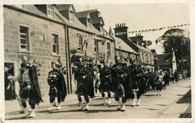 Dornoch Pipe Band marching along Castle Street