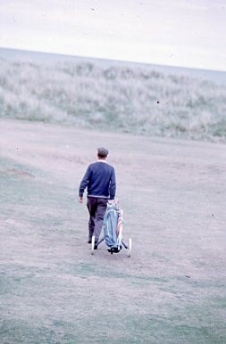 Player with golf trolley