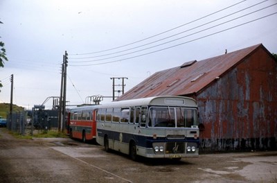 Single deck bus in grey and blue livery at Dornoch