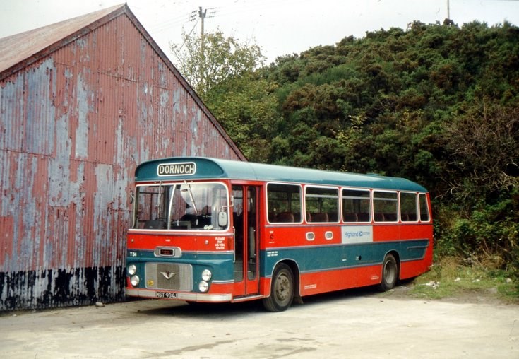 Single deck buses in red & blue livery at Dornoch