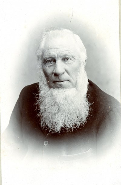 Studio head and shoulders photograph of bearded gentleman