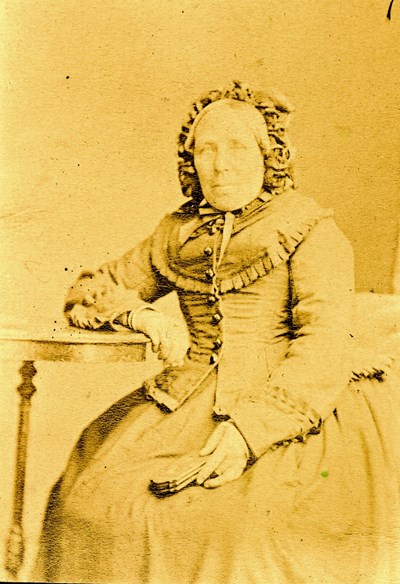 Sepia studio photograph of an elderly lady wearing a bonnet