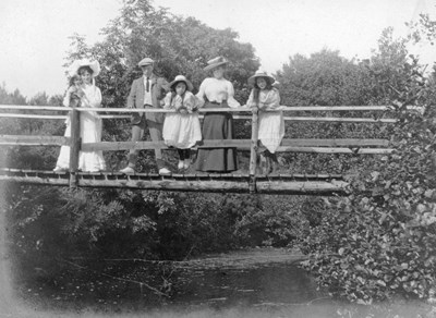 Grant family group standing on a wooden bridge