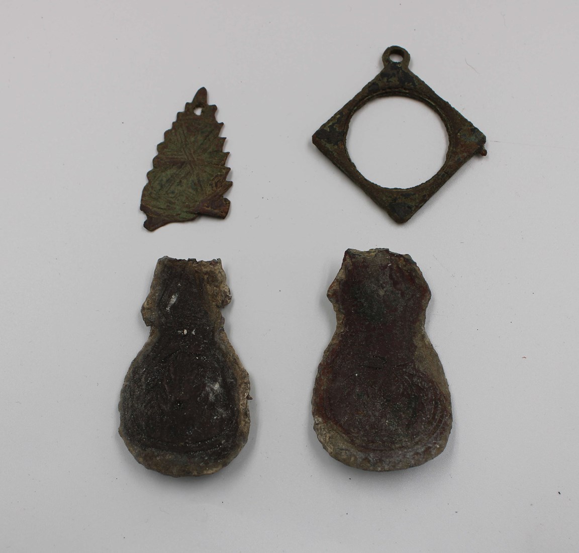 Four metal objects - probable harness ornaments