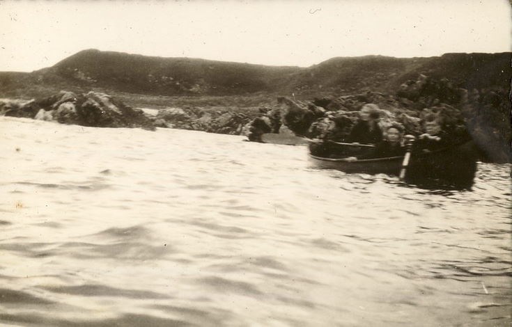 A woman, and two children, in a rowing boat