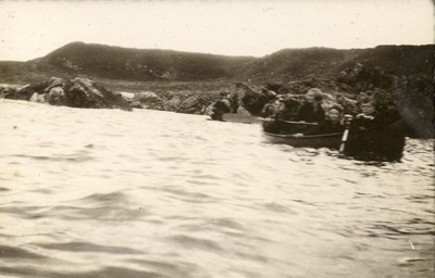 A woman, and two children, in a rowing boat