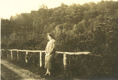 Woman standing against a single-rail fence