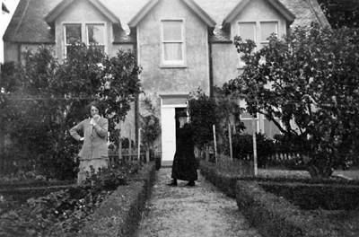 Two Ladies in the front garden of a house