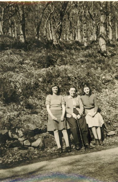 Group of lady and  two girls sitting beside road