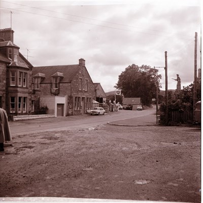 Main street of village, with war memorial  on the right