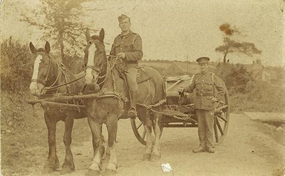 Two men in uniform with a two horse carriage