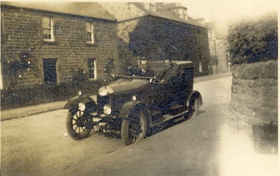 Open top car with two occupants in Dornoch c 1920